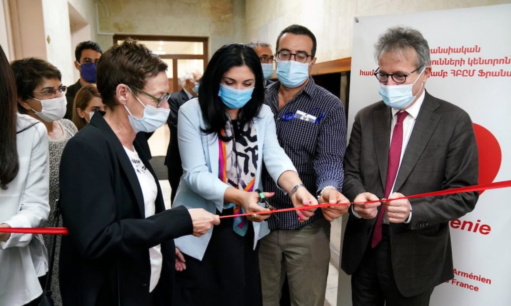 Four people are cutting the red tape.